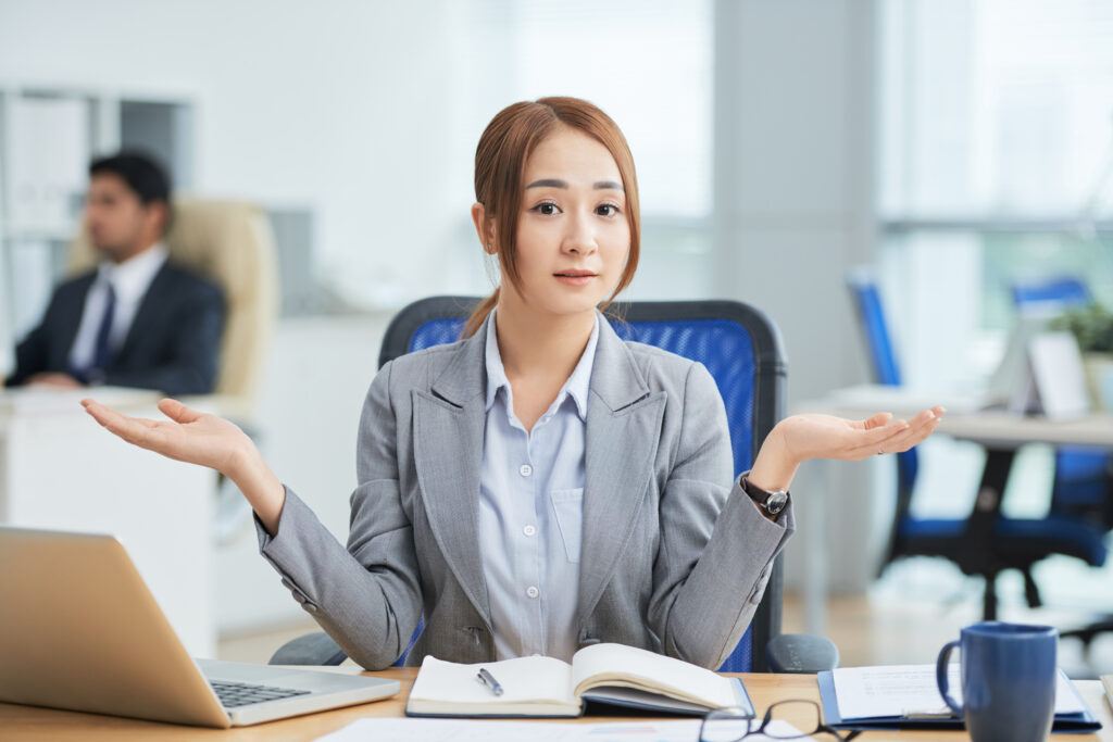 asian woman sitting at office desk wondering